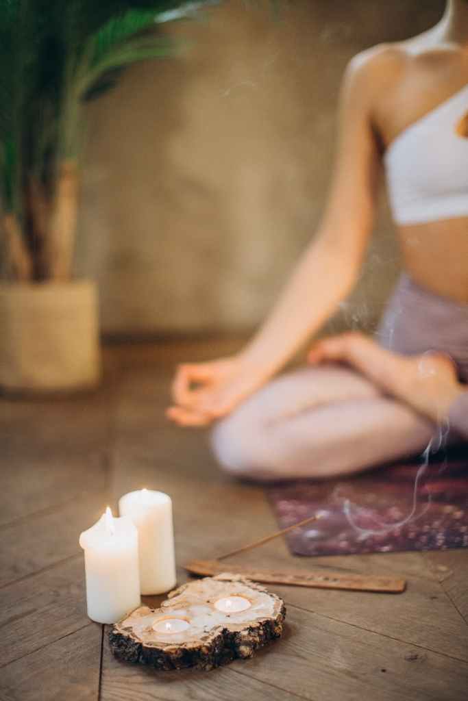 woman meditating with candles