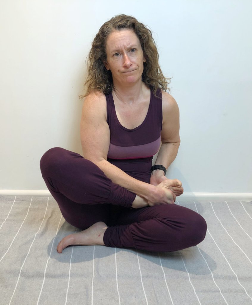 woman attempting yoga lotus pose
